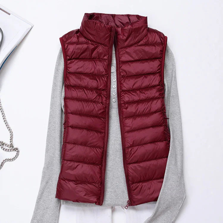 Maroon padded sleeveless jacket layered over light grey long sleeve shirt on white background