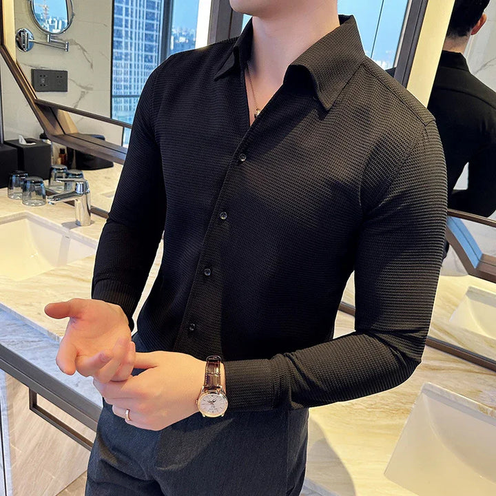 Man wearing fitted black textured long sleeve shirt and wristwatch in modern bathroom