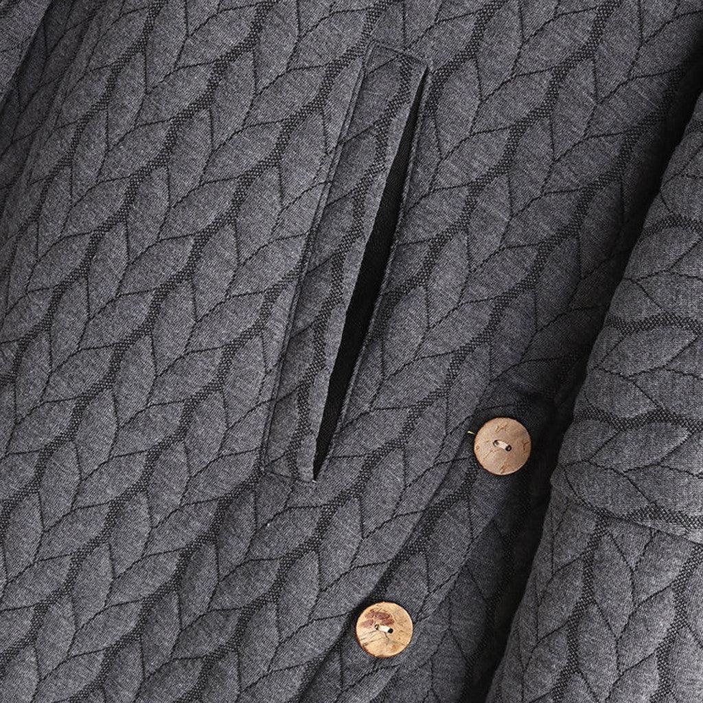 Close-up of a quilted gray fabric with diagonal leaf pattern, wooden buttons, and a side pocket