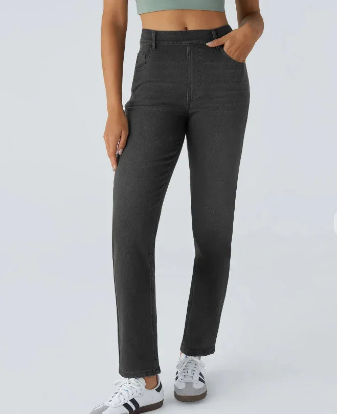 Woman wearing high-waisted black straight jeans with pockets and white sneakers