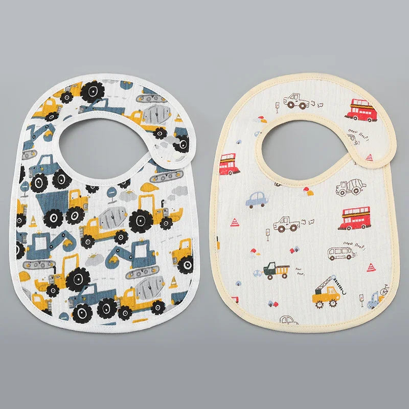 Two baby bibs with colorful construction and vehicle prints on gray background
