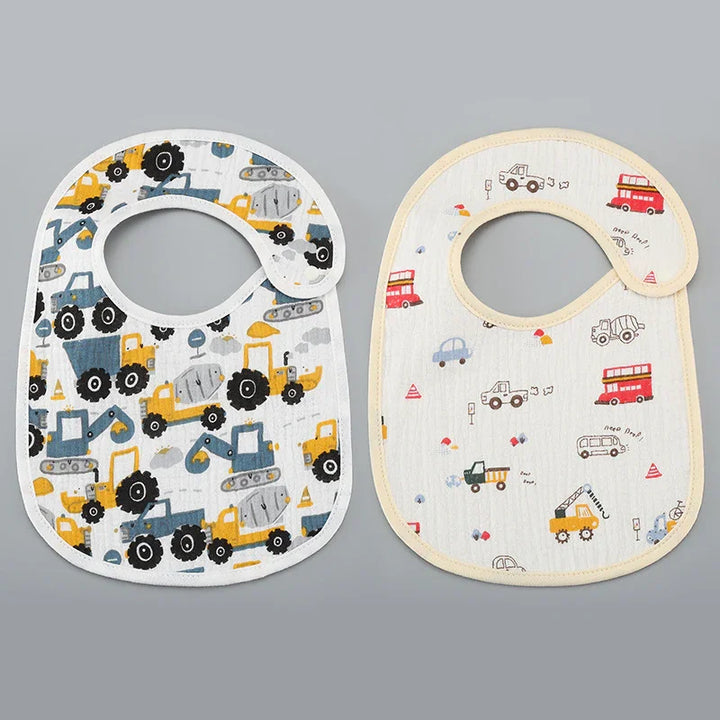 Two baby bibs with colorful construction and vehicle prints on gray background