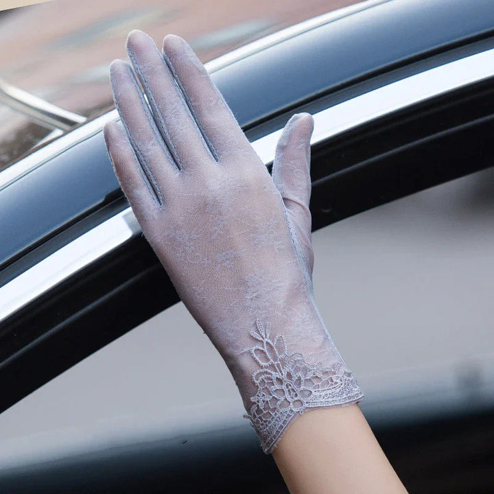Elegant lavender lace glove worn on hand resting outside a car window with black and silver trim