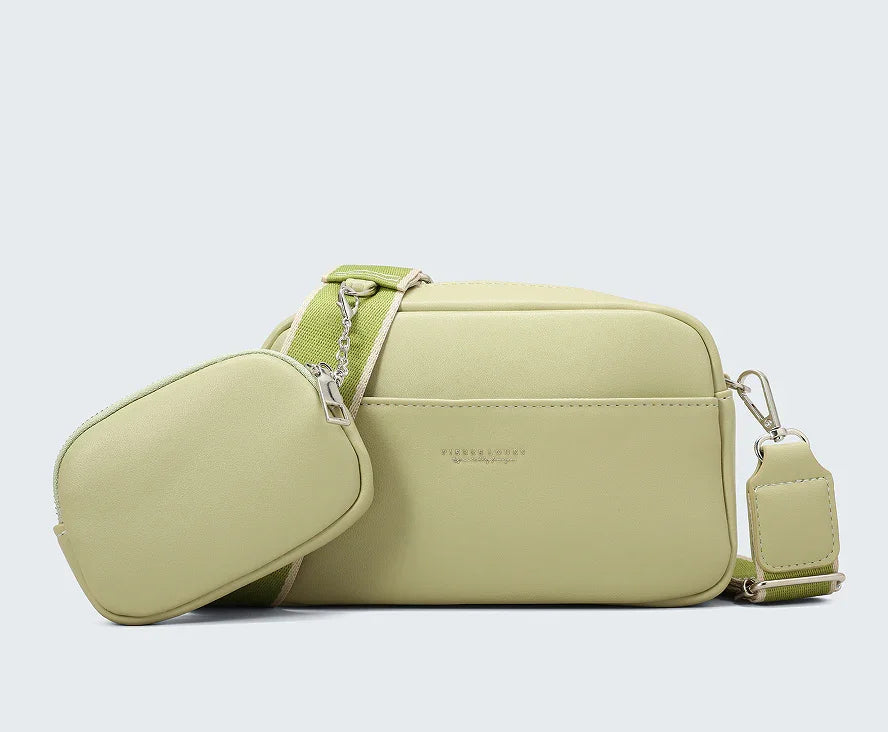light green crossbody bag with detachable small pouch and adjustable strap on gray background