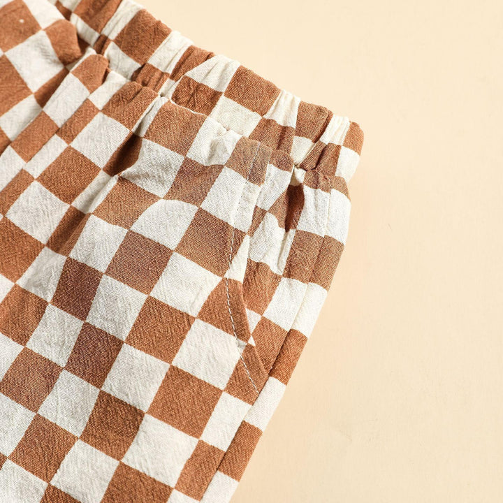Close-up of brown and white checkered elastic waistband pants pocket on beige background