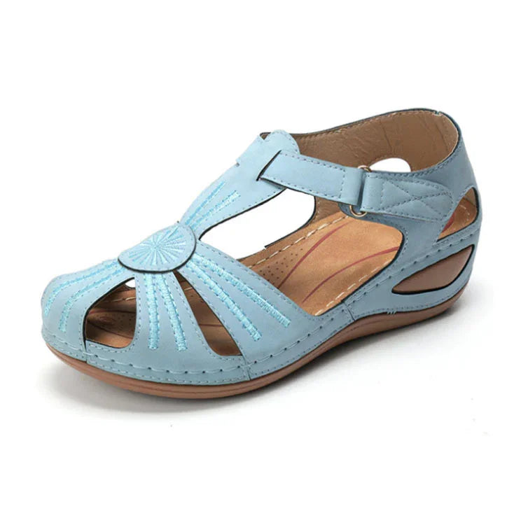 Light blue open-toe women’s sandal with decorative stitching and adjustable ankle strap