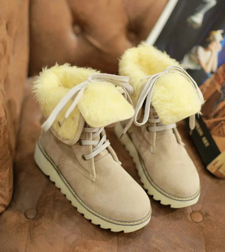 Beige winter boots with yellow faux fur lining and laces on brown suede surface