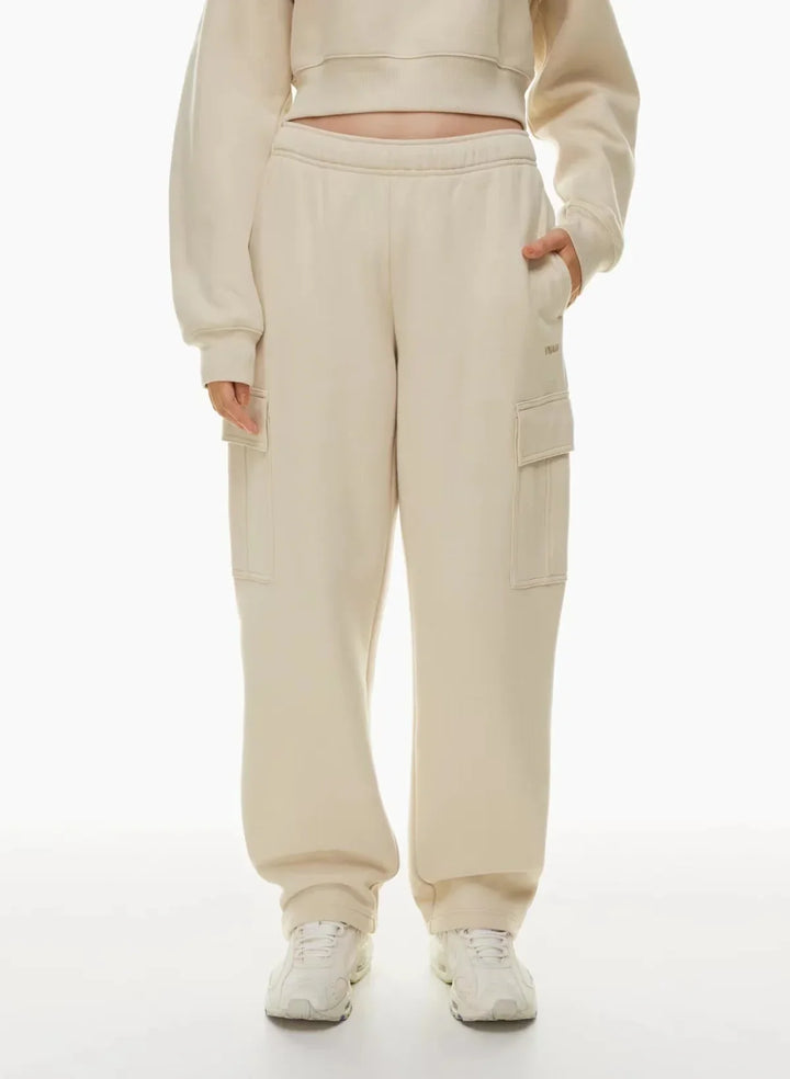 Beige cargo sweatpants with pockets, elastic waistband, and sneakers, casual style
