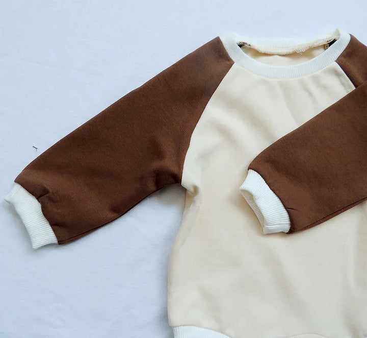 Beige and brown raglan sweatshirt with white ribbed cuffs and neckline on white background