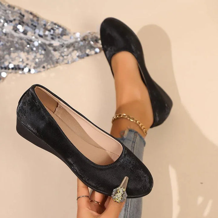 Black velvet ballerina flats with decorative rhinestone detail worn with jeans and a gold anklet