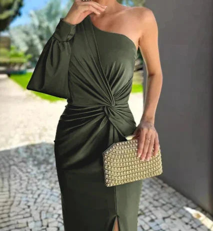 Woman wearing stylish olive green one-shoulder dress with knot detail, holding gold textured clutch