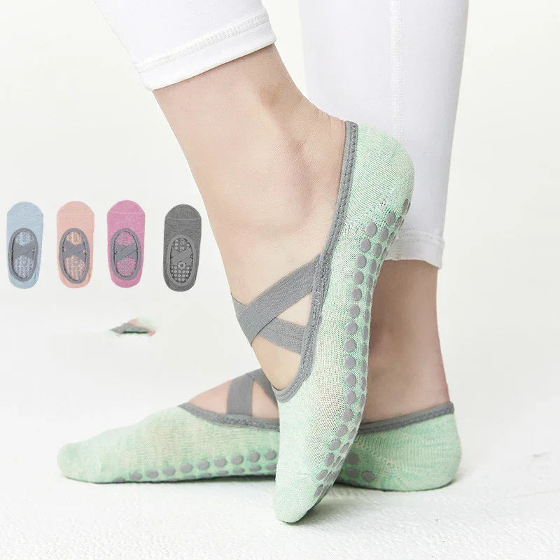 Person wearing mint green non-slip yoga socks with gray straps and dots, other color options shown
