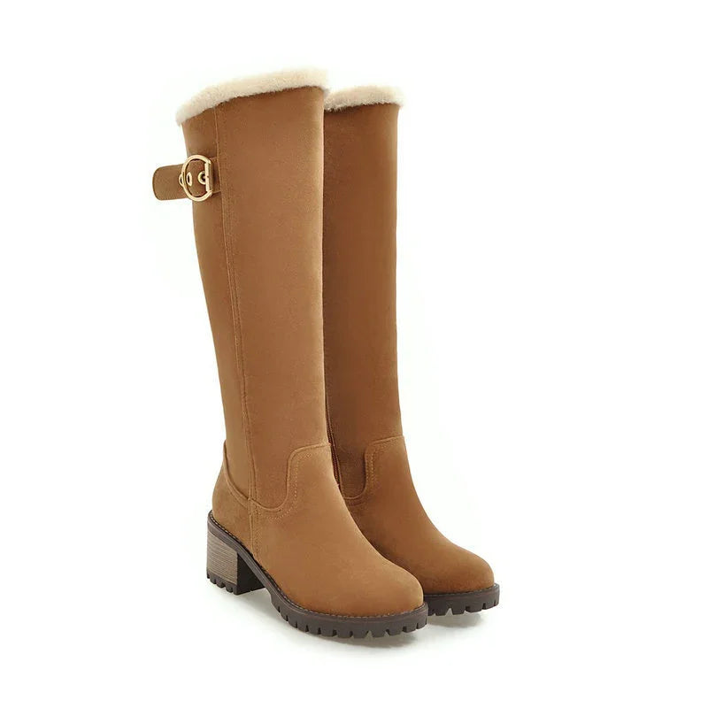 Tan knee-high winter boots with faux fur lining, side buckle, and block heel on white background