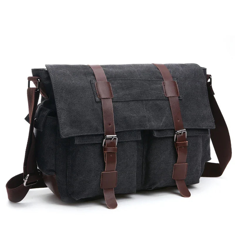 Dark gray canvas messenger bag with brown leather straps and buckles on white background