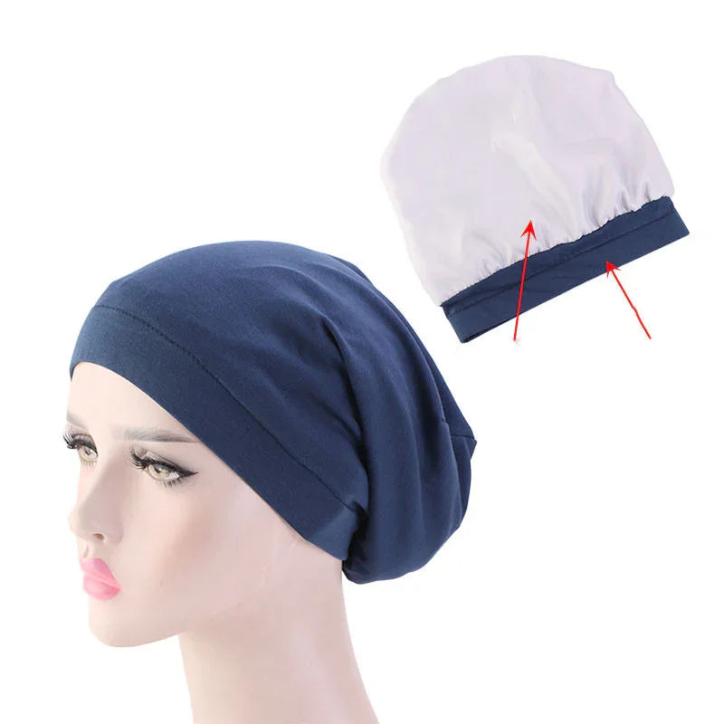 Navy blue chemo beanie hat on mannequin head with white inner lining and elastic band detail