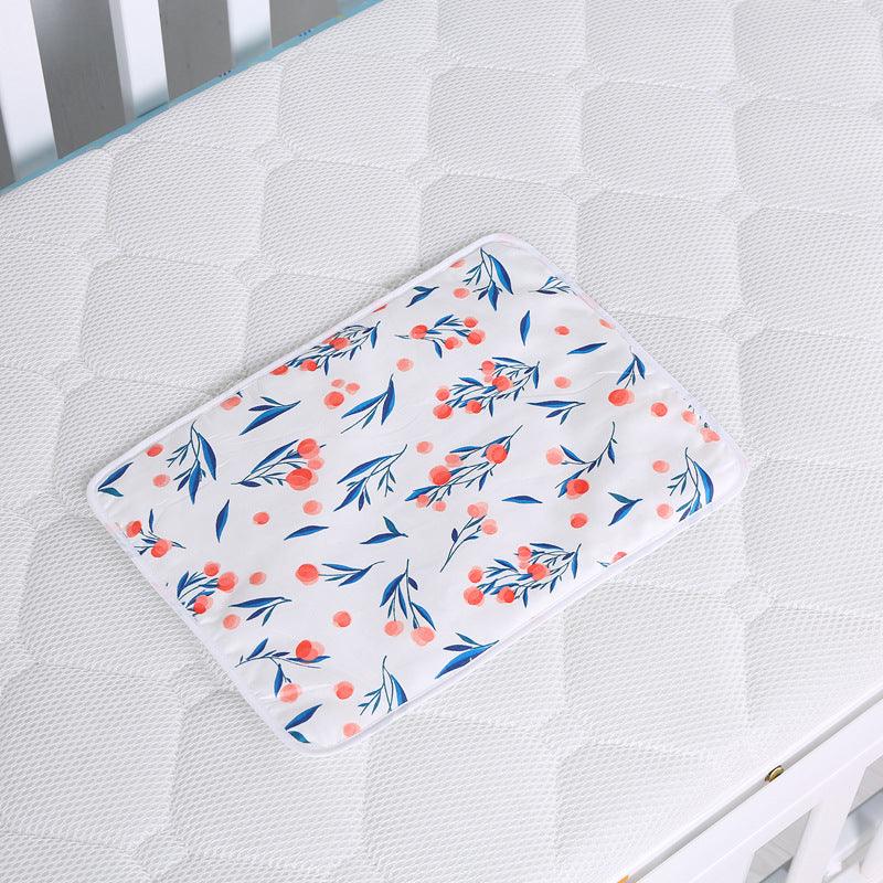 Waterproof baby changing mat with floral print on white mattress in crib