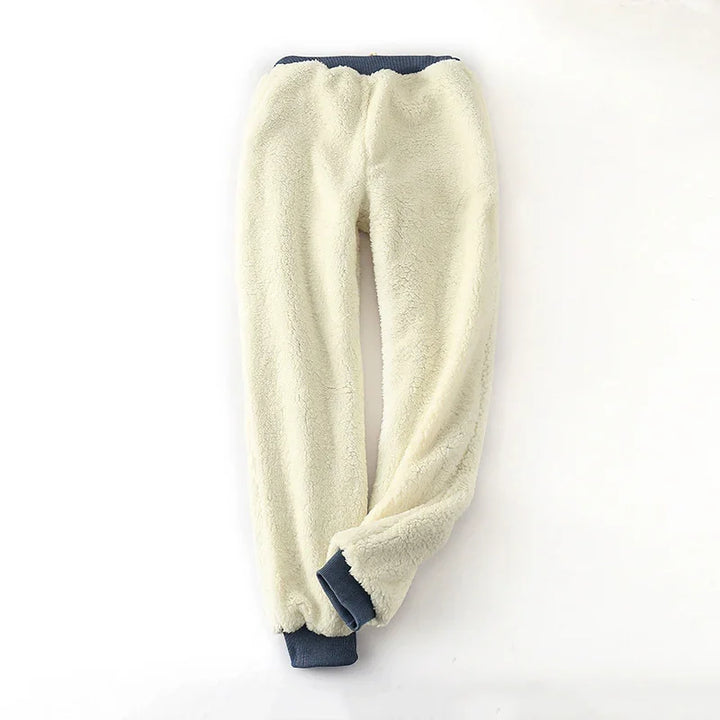 Cream sherpa fleece jogger pants with navy blue elastic waistband and cuffs on white background