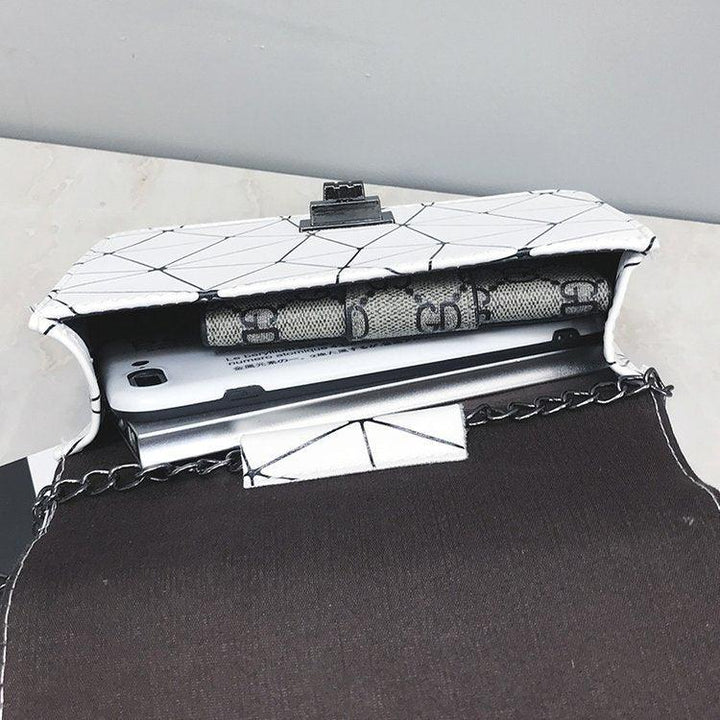 Open white geometric pattern chain purse holding a smartphone and a designer wallet on marble surface