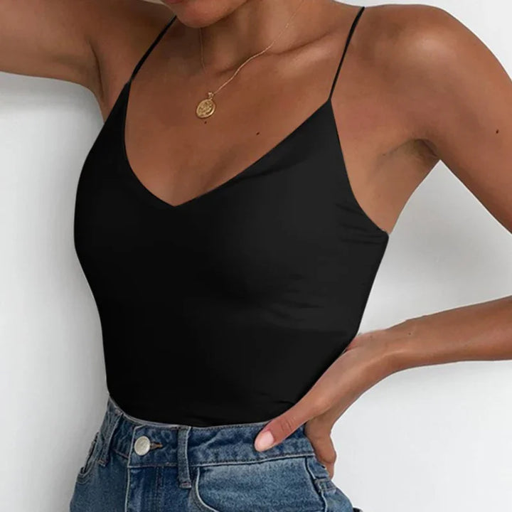 Woman wearing black spaghetti strap tank top and high-waisted blue denim jeans with gold pendant necklace