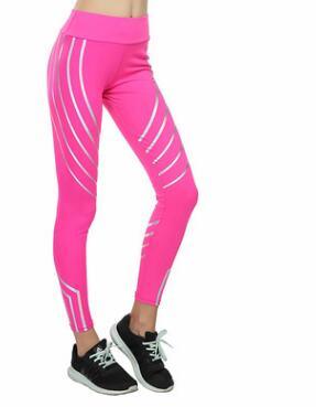 Woman wearing bright pink athletic leggings with white diagonal stripes and black sneakers