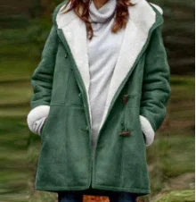 Woman wearing a green hooded wool coat over a white top outdoors