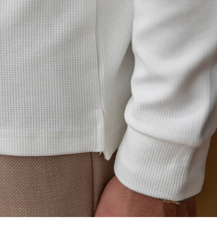 Close-up of white waffle knit long sleeve shirt cuff and beige pants detail