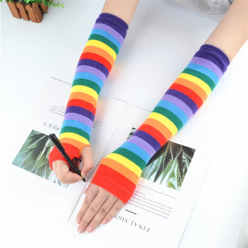 Person wearing rainbow striped arm warmers while writing on paper with a pen