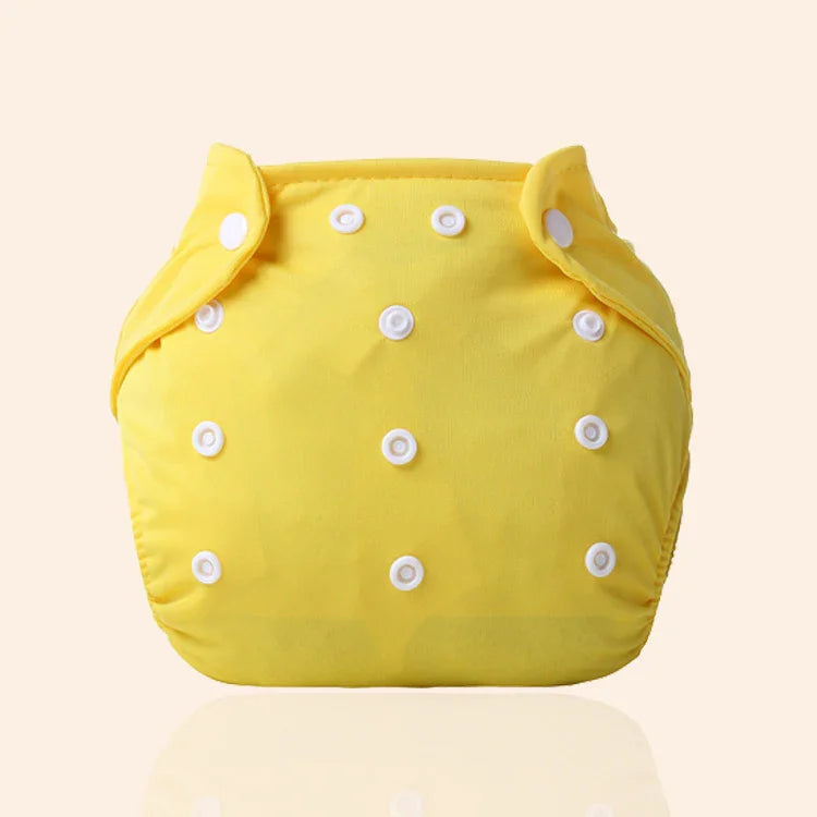 Yellow reusable cloth diaper with white snap buttons on a neutral background