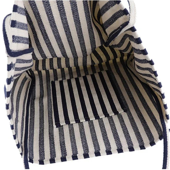 Interior view of a navy and white striped fabric bag with a small flat pocket