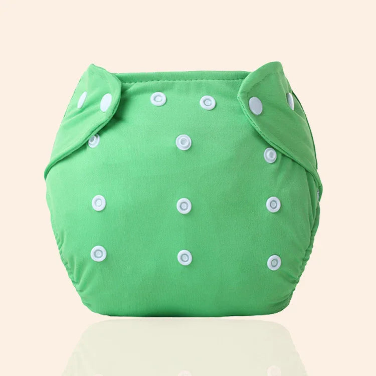 Green reusable cloth diaper with multiple white snap buttons on beige background