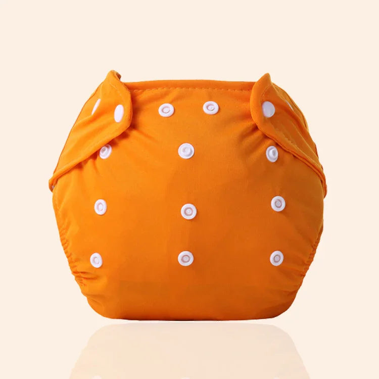 Orange adjustable cloth diaper with white snap buttons on a beige background