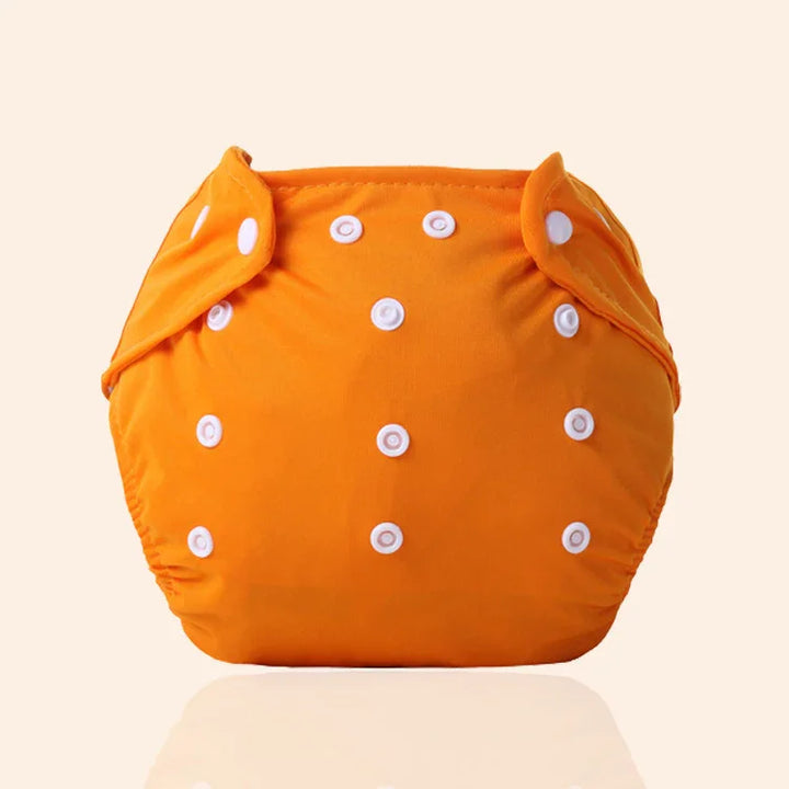 Orange adjustable cloth diaper with white snap buttons on a beige background