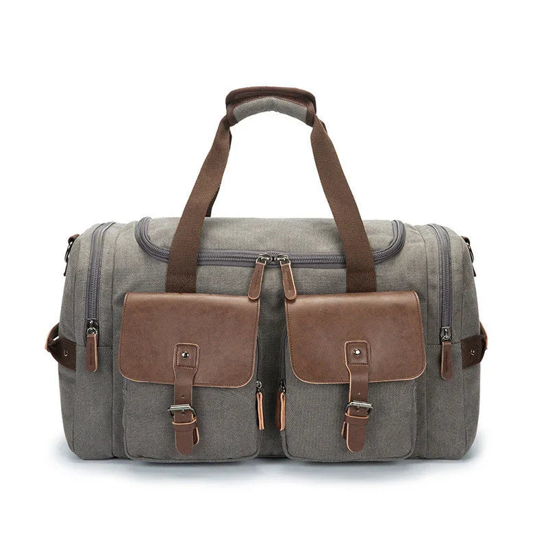 Gray canvas duffel bag with brown leather pockets and handles, multiple zippered compartments