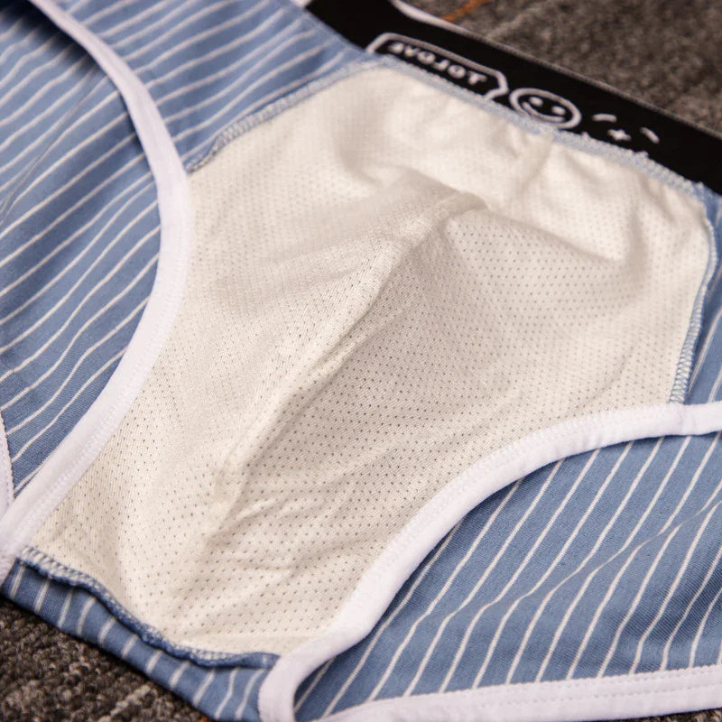 Close-up of blue and white striped underwear with breathable mesh inner lining on fabric surface