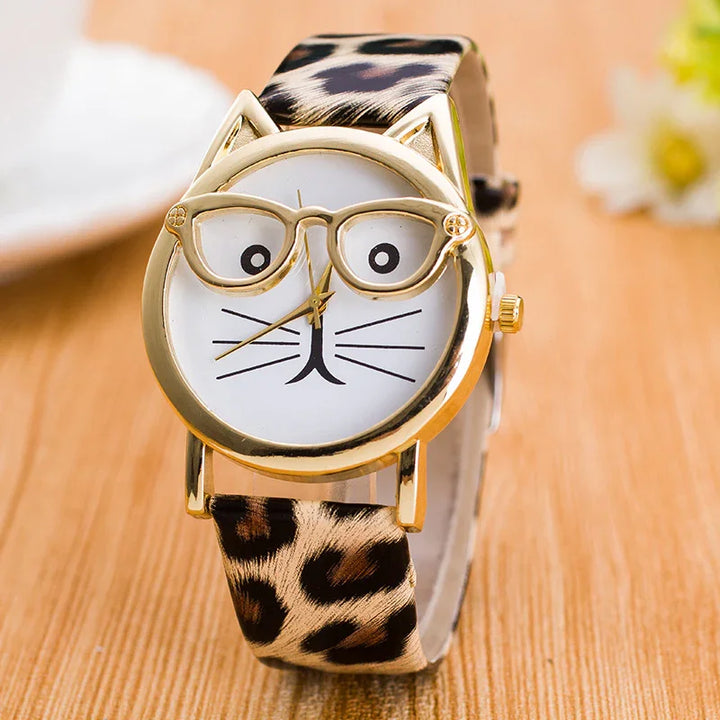 Gold cat watch with leopard print strap and glasses frame design on wooden surface