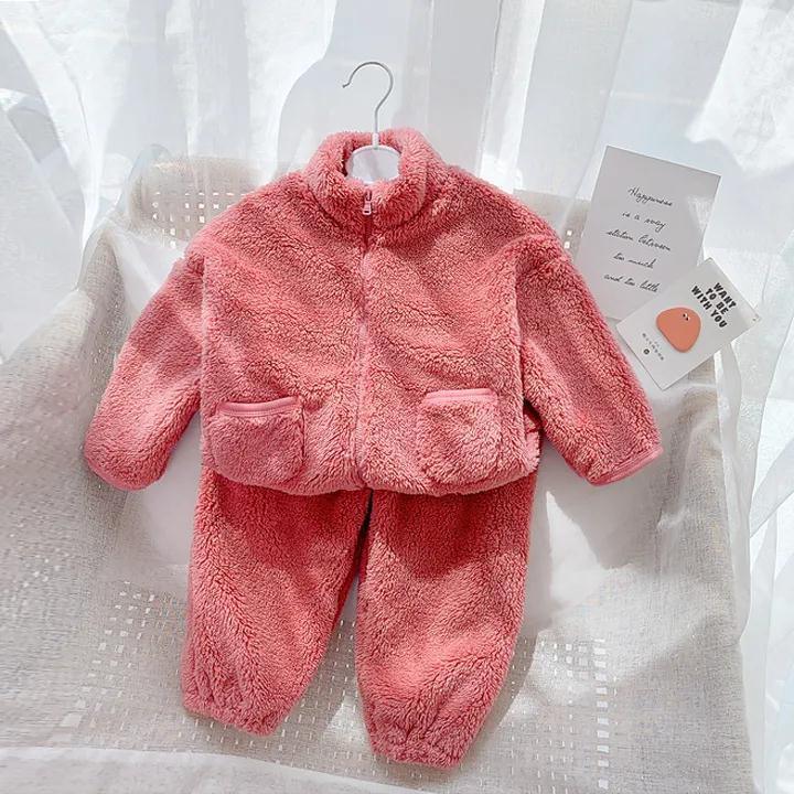 Soft pink plush toddler jacket and pants set hanging on chair in natural light