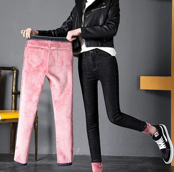 Woman wearing black jeans with pink fleece lining holding matching pink fleece-lined jeans indoors