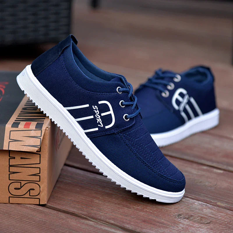Blue casual lace-up men's shoes with white soles displayed on wooden floor and box