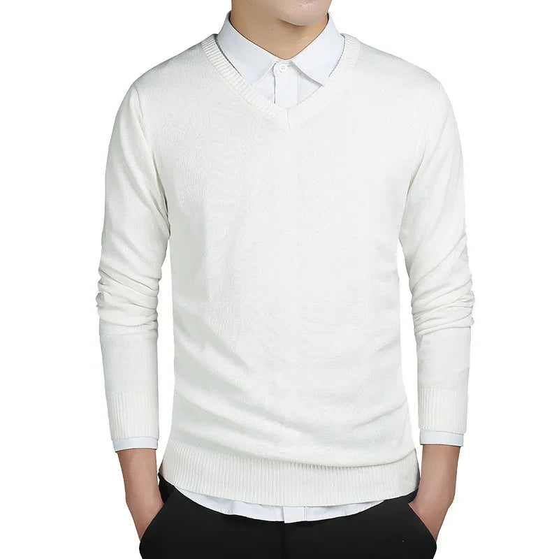 white V-neck sweater worn over white shirt with black pants on male model
