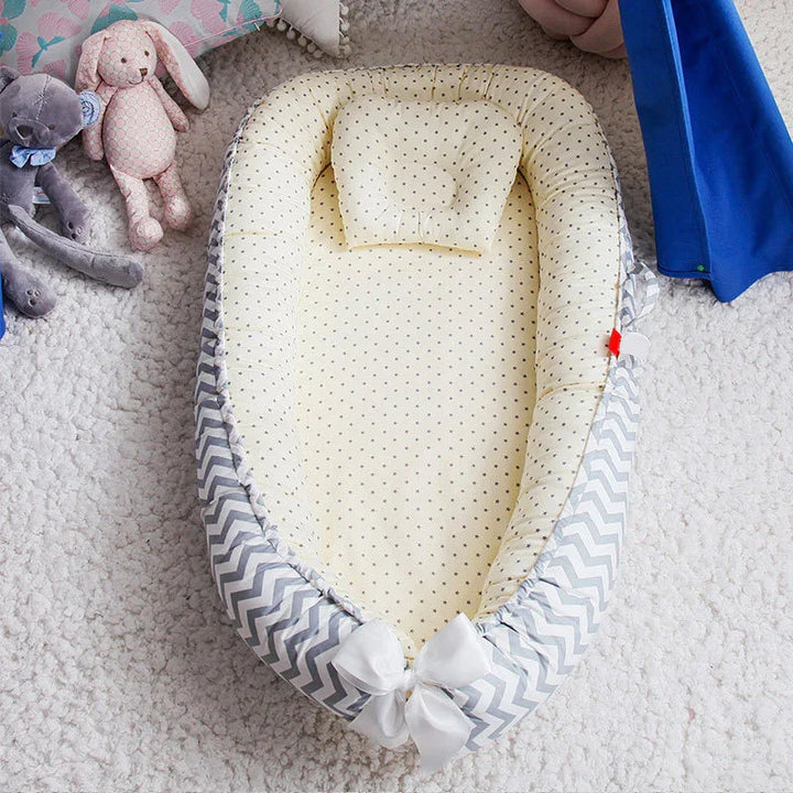 Baby lounger with yellow starry cushion and gray chevron border on white carpet with stuffed toys