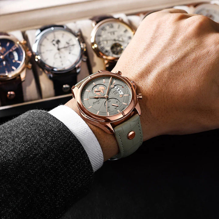 Elegant rose gold wristwatch with grey dial and leather strap on a wrist, watch collection in background