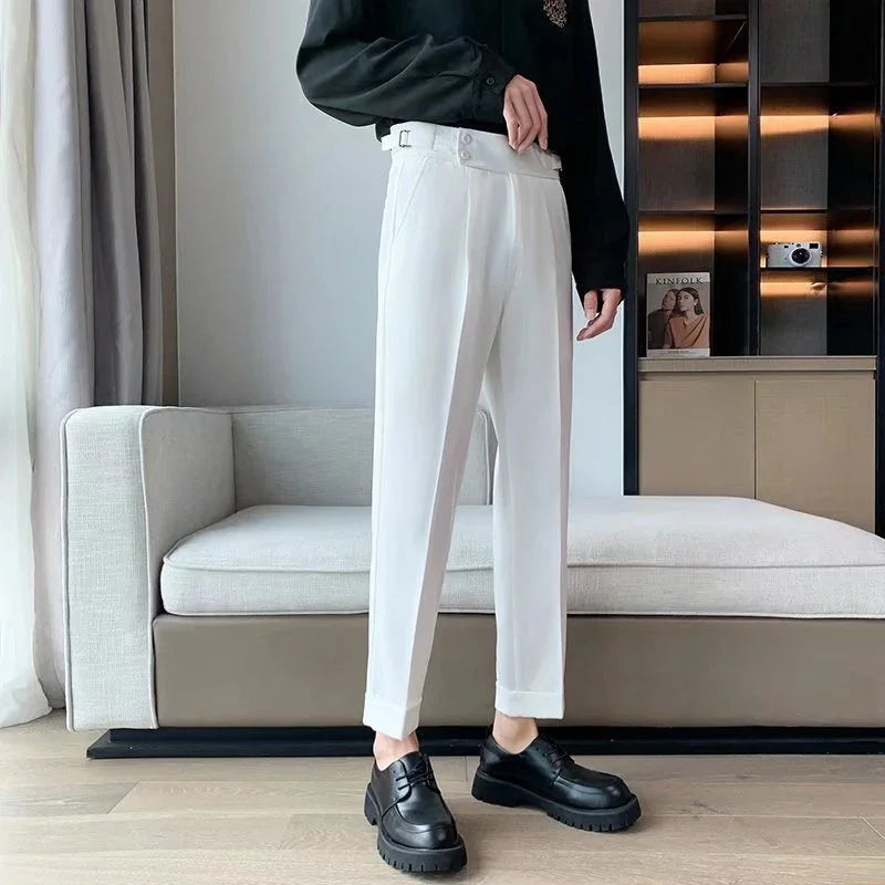 Person wearing white tailored pants and black leather shoes standing in modern living room