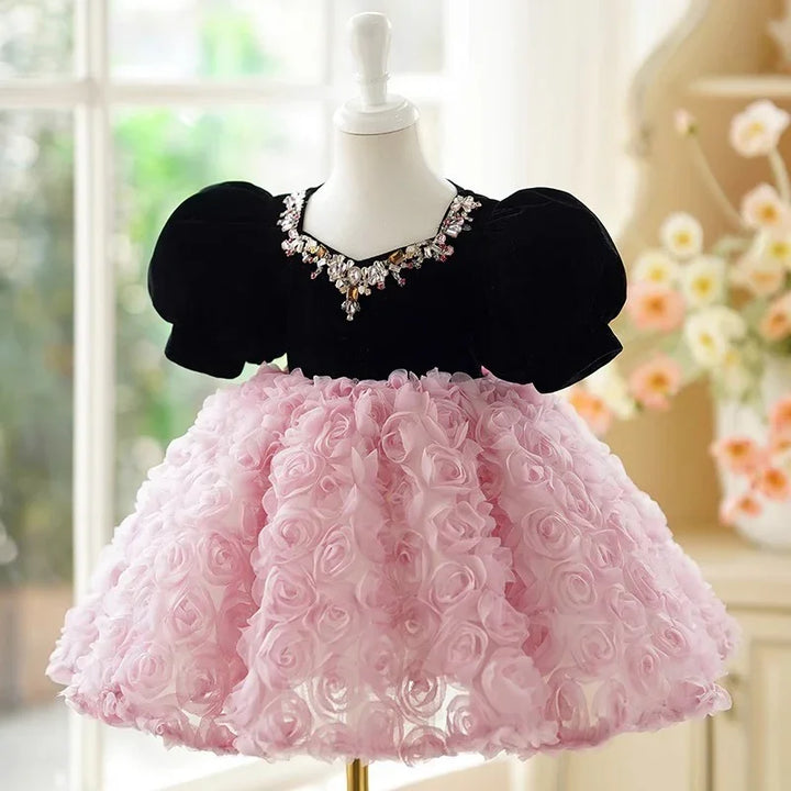 Elegant baby dress with black velvet puff sleeves and embellished neckline, pink floral rosette skirt