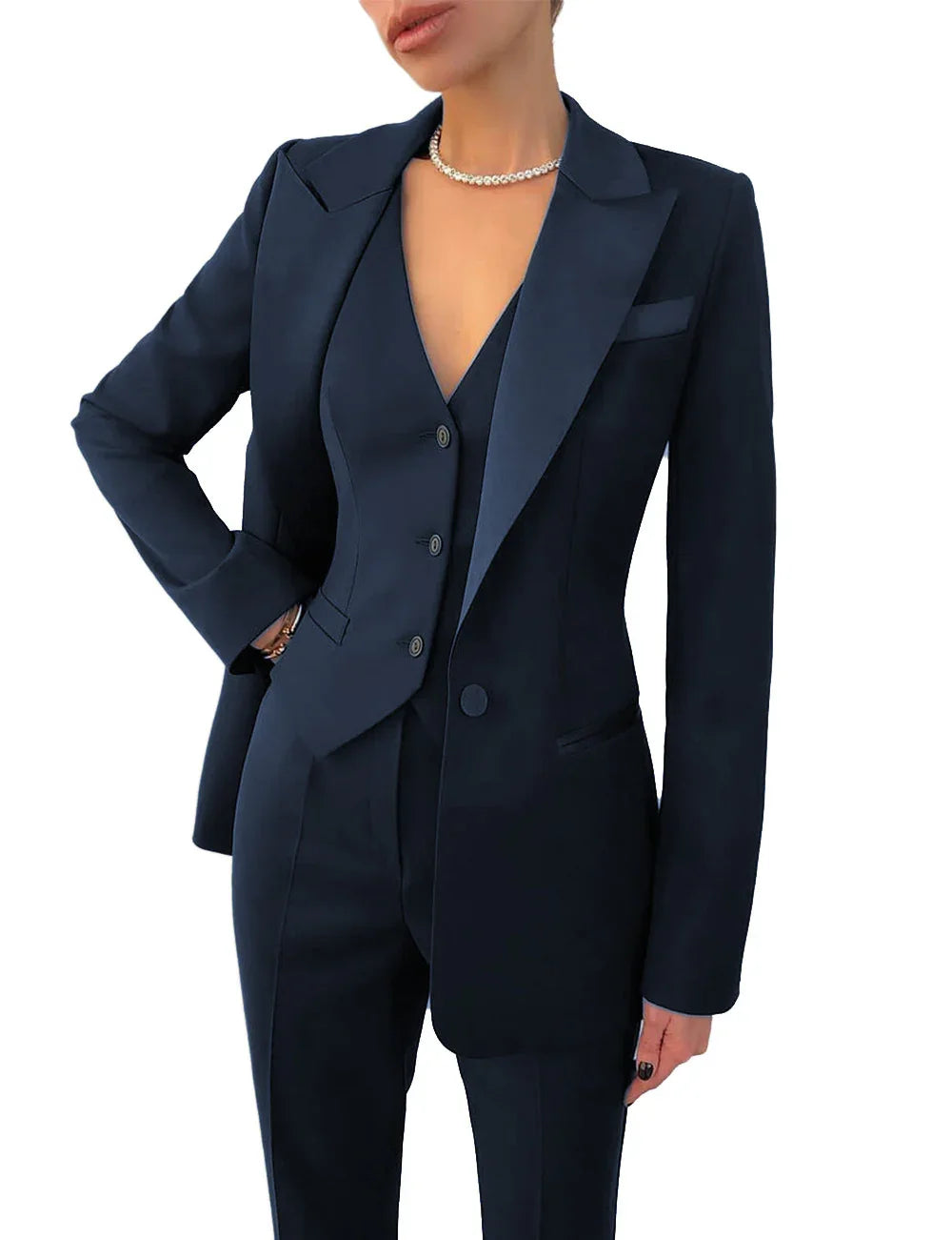 Woman in a navy three-piece tailored suit with blazer, vest, and pants, wearing a pearl necklace