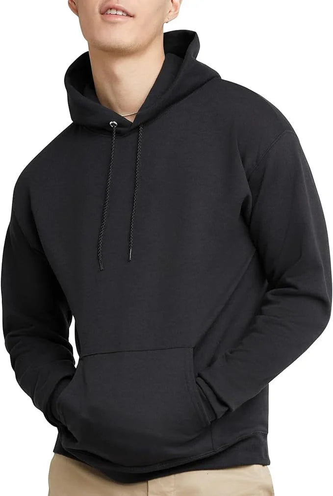 Man wearing plain black hoodie with front pocket and drawstrings, beige pants, white background