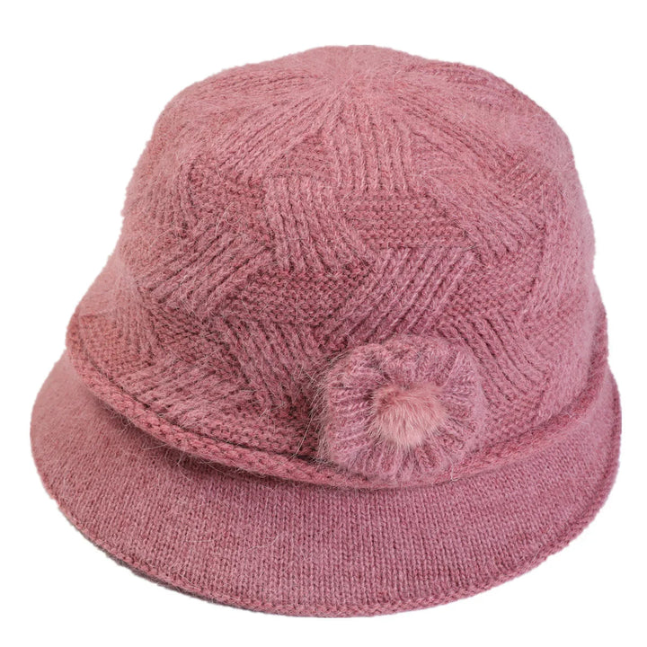 Pink knitted wool bucket hat with textured pattern and decorative flower detail