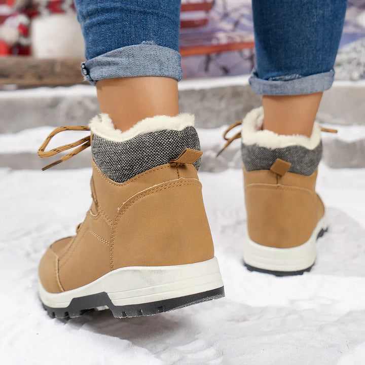 Women wearing tan winter boots with fur lining and gray fabric cuff on snowy ground