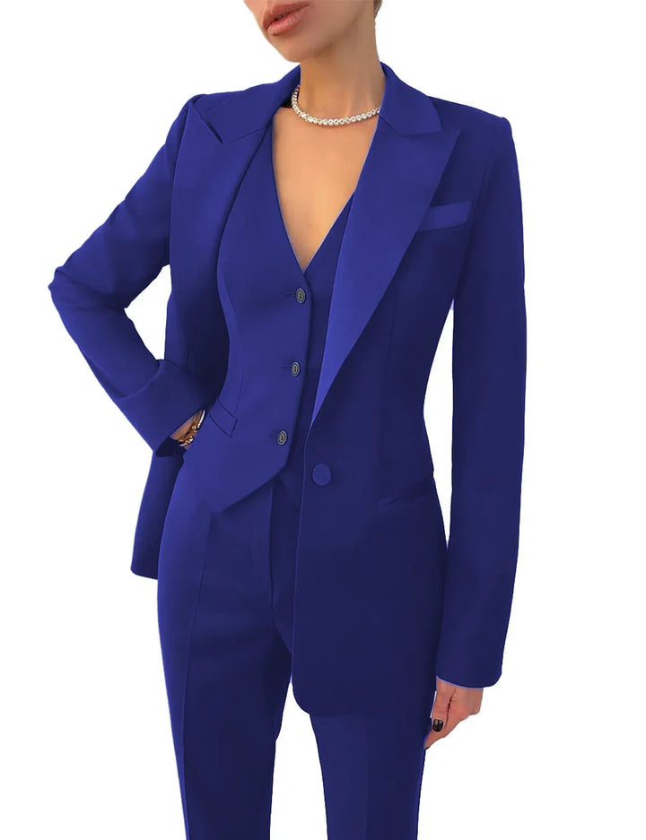 woman in royal blue tailored pantsuit with blazer and vest, wearing pearl necklace