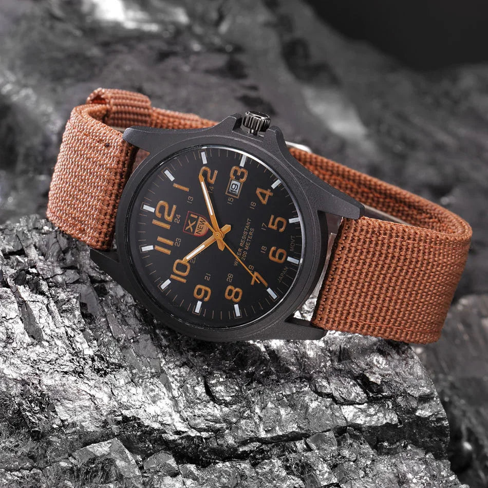 Black wristwatch with orange numerals and brown fabric strap on textured dark rock surface