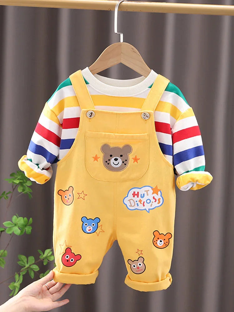 Yellow baby overalls with bear faces and stars, paired with a colorful striped long-sleeve shirt on hanger